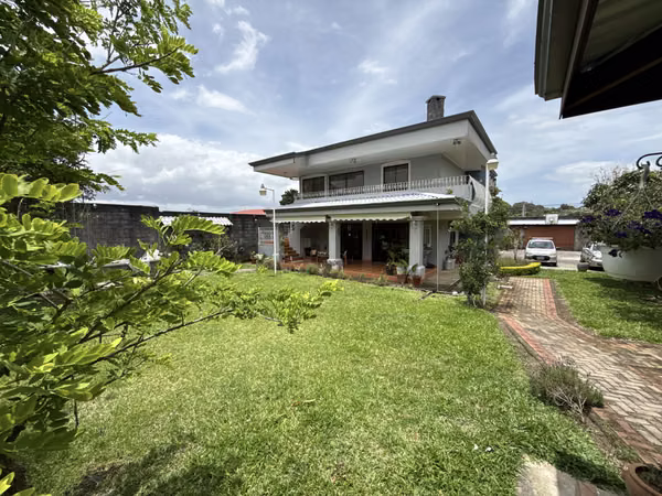 Detached house for rent in a residential neighborhood (not a gated community), featuring a yard and large parking area. 