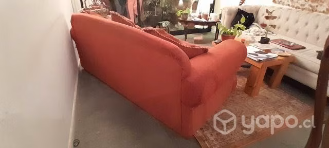 Gran sofá de tela color terracota con cojines