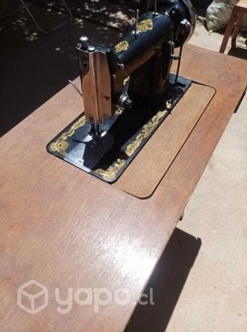 Maquina de cocer con mesa funcionando