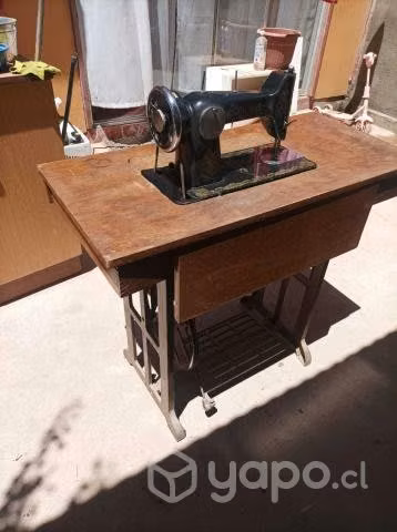 Maquina de cocer con mesa funcionando