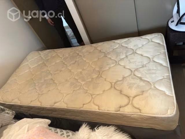Cama de una plaza con sabanas y cubrecama