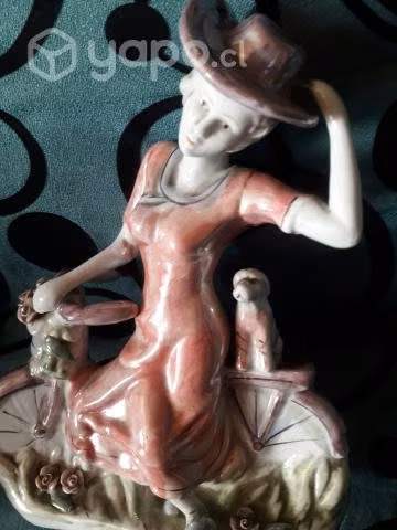Estatuilla porcelana dama en bici con mascota