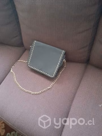 Cartera de cuero negra con correa metálica dorada