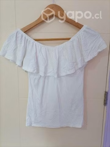 Polera blanca ceñida al cuerpo, y hombros al aire