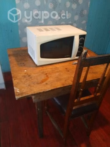 Una mesa un micróonda un transportador