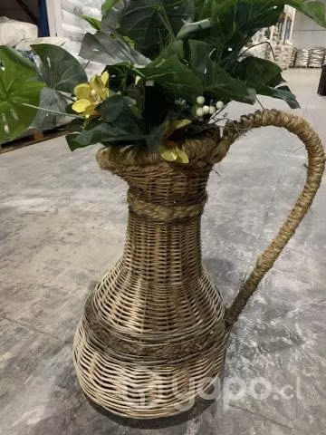 Jarro de mimbre mas plantas y flores de plástico.