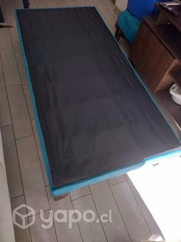 Cama de una plaza con mueble pequeño