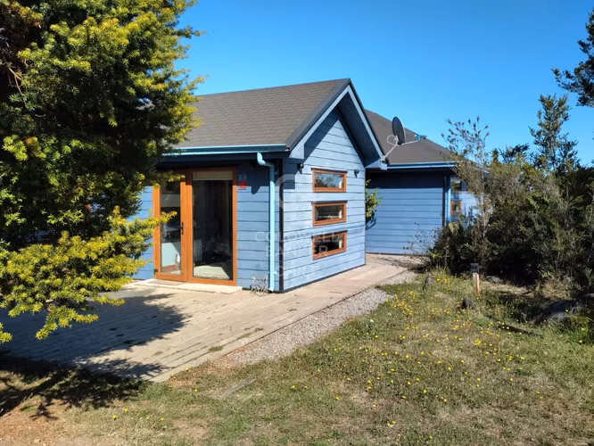 Casa en parcela con bosque nativo y riachuelo.