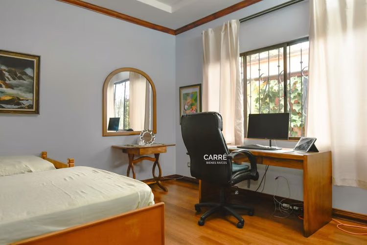 Casa de un nivel rodeada de jardines, en condominio.