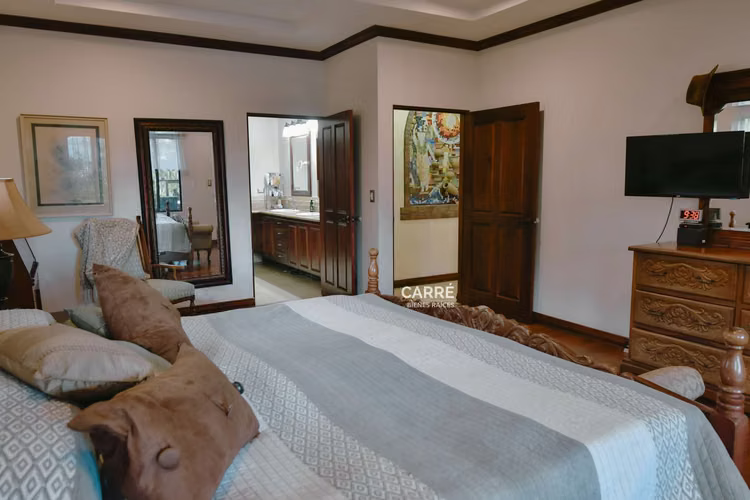Casa de un nivel rodeada de jardines, en condominio.