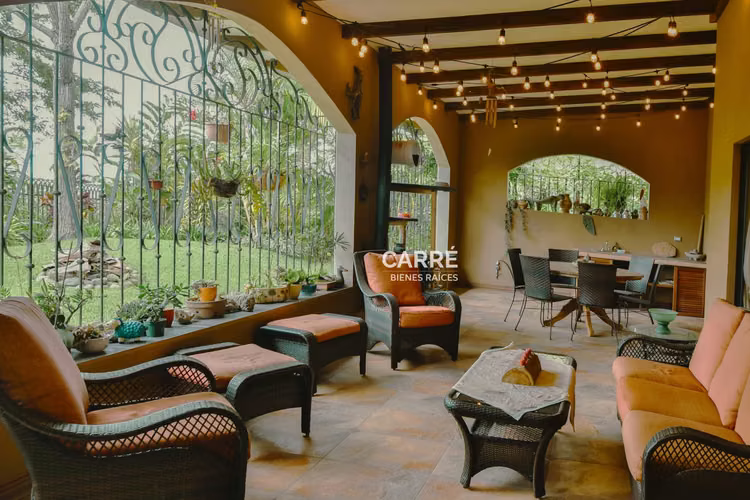 Casa de un nivel rodeada de jardines, en condominio.