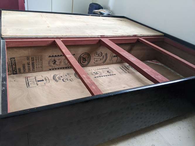 Cama tipo caja muy bien mantenida con mucho espacio de almacenamiento.